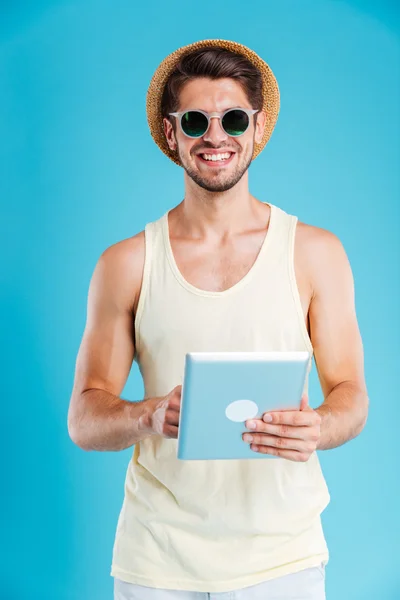 Portrait de jeune homme heureux debout et utilisant une tablette — Photo