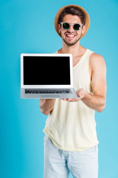 陽気な若い男立っていると空白の画面のノート パソコン — ストック写真