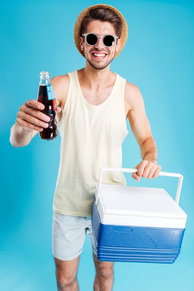 Hombre alegre que le da bolsa de enfriamiento y botella de refresco — Foto de Stock