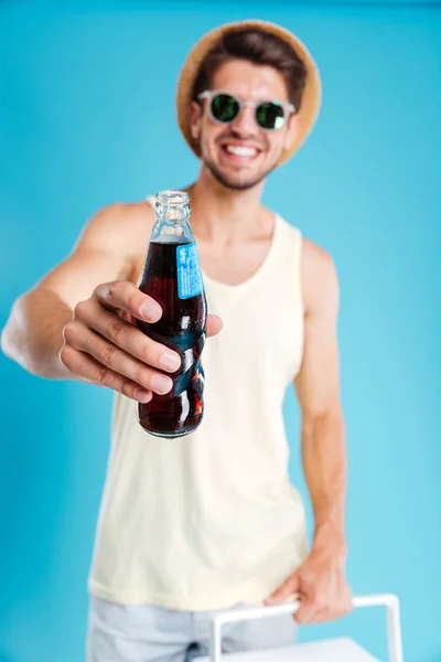 Feliz joven atractivo dándote una botella de refresco — Foto de Stock