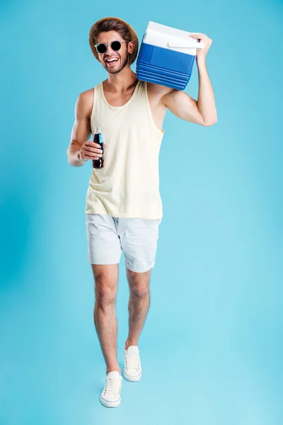 Чоловік з мішком для охолодження на плечі, що йде і п'є соду — стокове фото