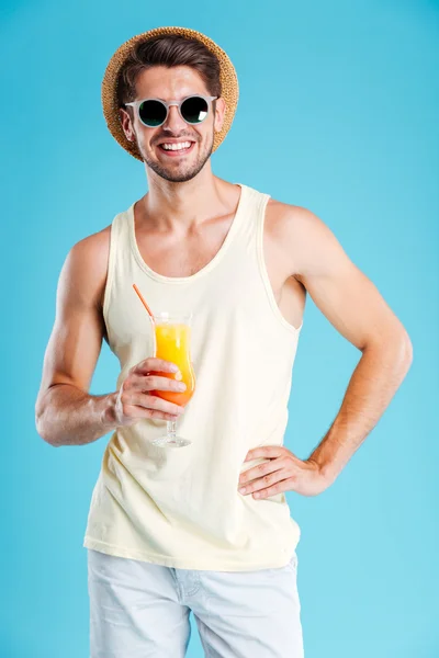 Щасливий чоловік у капелюсі та сонцезахисних окулярах зі склянкою соку — стокове фото