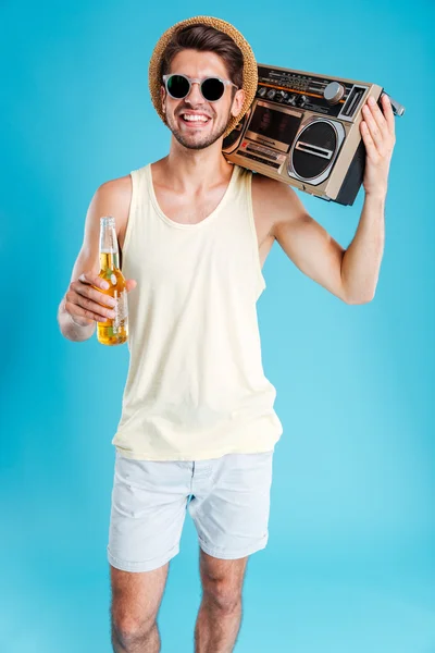 Mosolygó csinos, fiatal férfi boombox és üveg sört — Stock Fotó