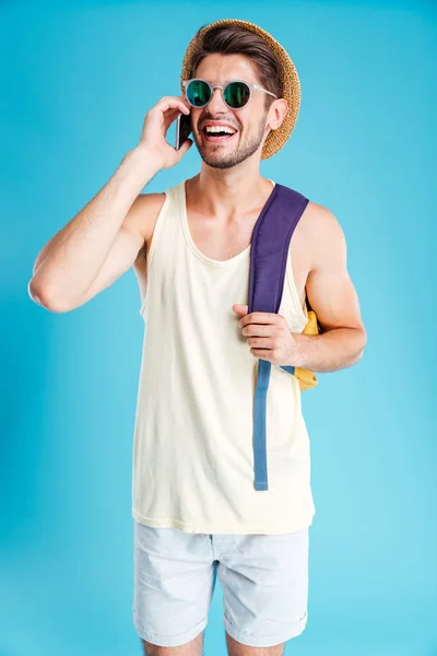 Χαρούμενος νεαρός άνδρας με σακίδιο μιλάμε για κινητό τηλέφωνο — Φωτογραφία Αρχείου