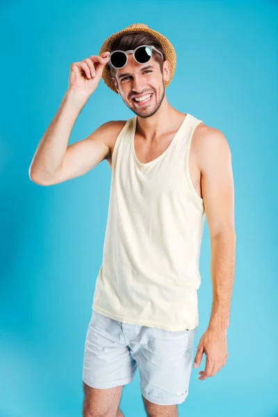 Retrato de joven feliz en pantalones cortos, sombrero y gafas de sol — Foto de Stock