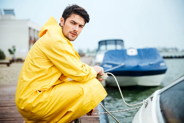 英俊的年轻男子，穿黄色时钟在码头 — 图库照片