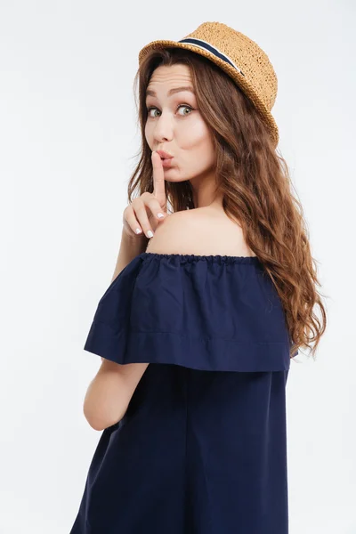 Beautiful young woman in hat showing silence gesture — Stock Photo, Image