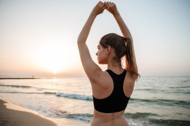 yoga plaj boyunca uzanan güzel genç kadın