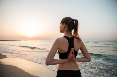 yoga plaj boyunca uzanan güzel genç kadın