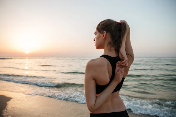 Bella giovane donna che si estende durante lo yoga sulla spiaggia — Foto Stock