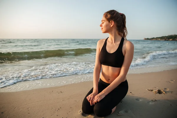 Portret van een mooi meisje zitten buiten op het strand — Stockfoto