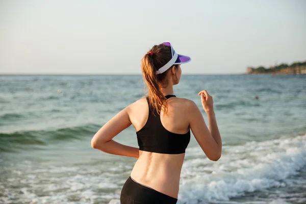 Mujer joven y saludable corriendo en la playa — Foto de Stock