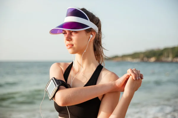 Subcampeón de fitness haciendo rutina de calentamiento en la playa antes de correr — Foto de Stock