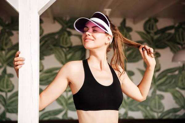 Lachende vrouw rusten na workout op palm patroon achtergrond verlaat — Stockfoto