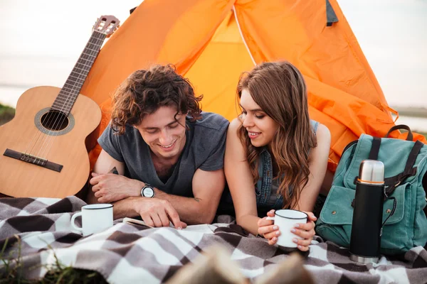 Happy couple camping on the beach laying in the tent — Stock Photo, Image