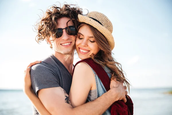 Casal sensual com mochilas de pé e abraçando ao ar livre — Fotografia de Stock