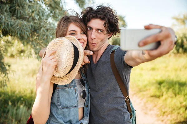 Alegre pareja w senderismo en el bosque y hacer selfie — Foto de Stock