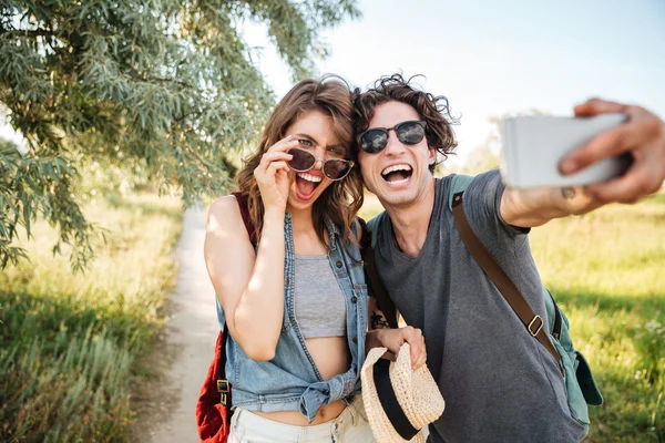 Casal alegre w caminhadas na floresta e fazer selfie — Fotografia de Stock