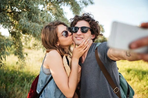 Casal com mochilas caminhadas na floresta e fazer selfie — Fotografia de Stock