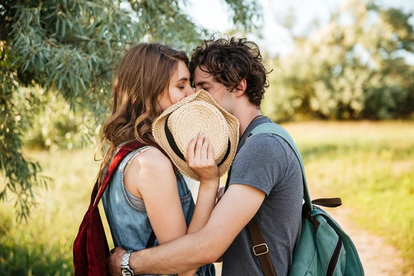 Casal apaixonado beijando com os olhos fechados na floresta — Fotografia de Stock