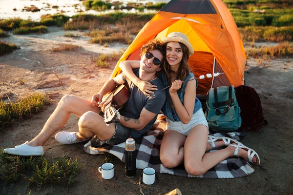 Felice giovane coppia divertirsi campeggio da un lago — Foto Stock