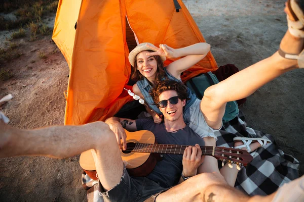 Felice giovane coppia divertirsi campeggio da un lago — Foto Stock