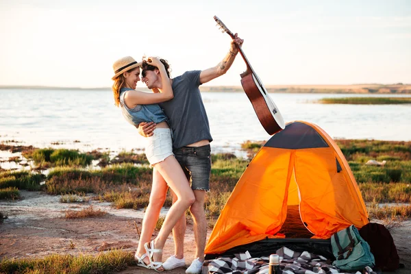 Coppia felice innamorata che si abbraccia davanti a una tenda — Foto Stock