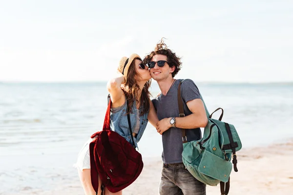 Feliz joven pareja de pie en la playa y besándose —  Fotos de Stock