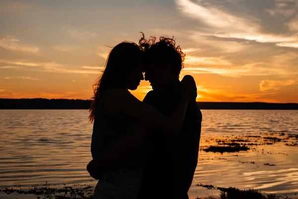 Lovers standing on a beach and looking at each other — Stock Photo, Image