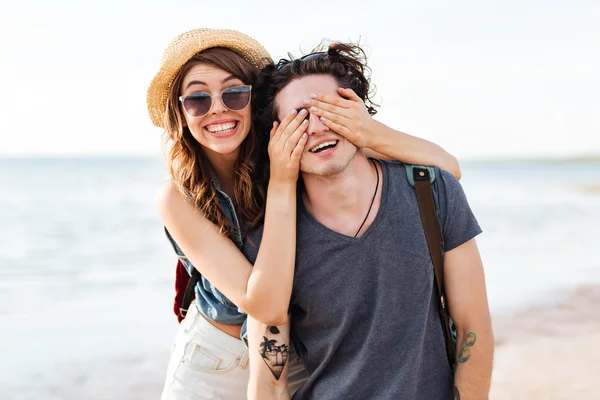 Веселая молодая пара веселится на пляже — стоковое фото