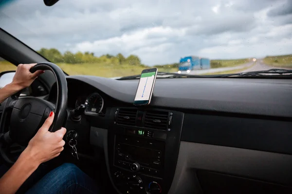 Handen van vrouw stuurprogramma drijven op weg in de regen — Stockfoto