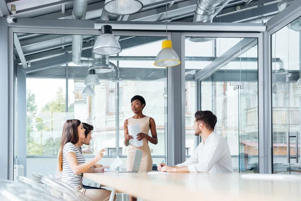 Jóvenes empresarios discuten informe financiero en sala de conferencias — Foto de Stock