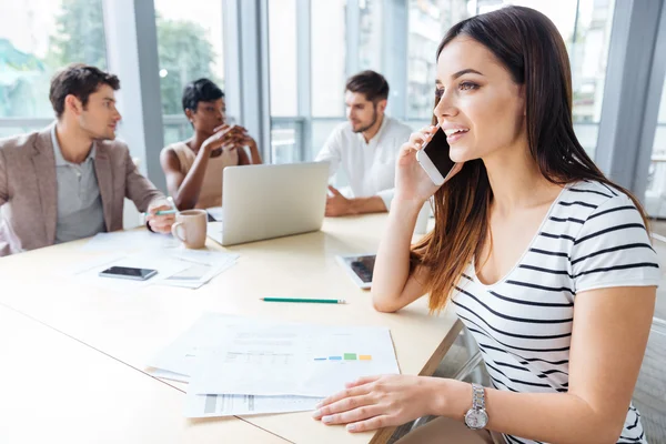 Joyeux succès femme parlant sur téléphone portable lors d'une réunion d'affaires — Photo