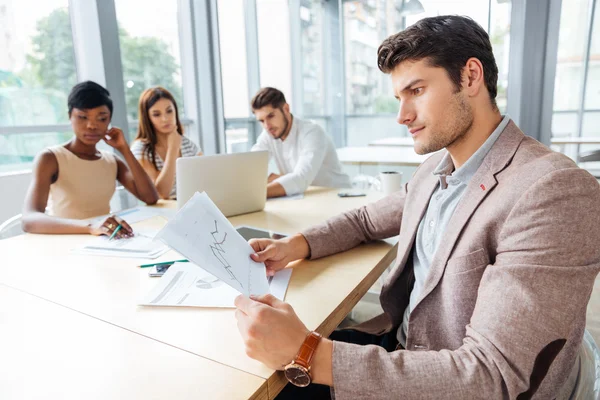 Empresario sentado y creando una presentación con el equipo de negocios en la oficina — Foto de Stock