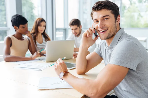 Affärsman som pratar i mobiltelefon medan du arbetar med verksamhet team — Stockfoto