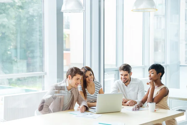 Equipo de negocios feliz trabajando con el ordenador portátil juntos en la oficina —  Fotos de Stock