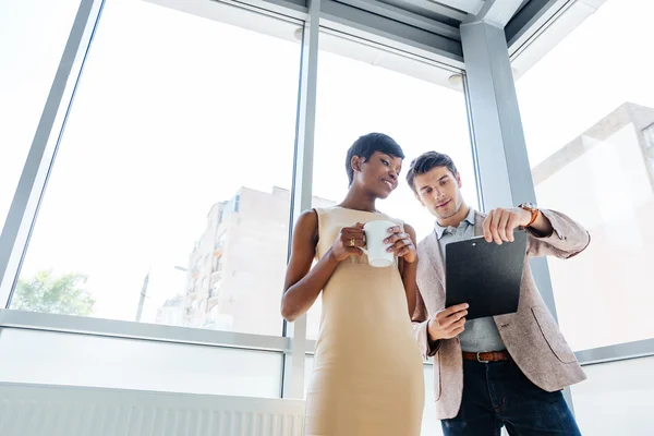 Feliz joven empresario y mujer de negocios hablando en el cargo — Foto de Stock