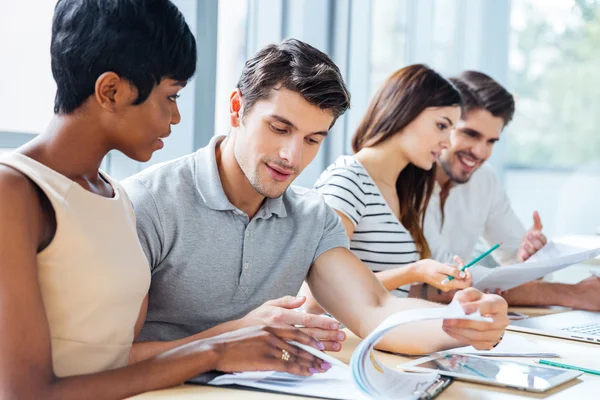 Serious young people sitting and creating business plan in office — Stock Photo, Image