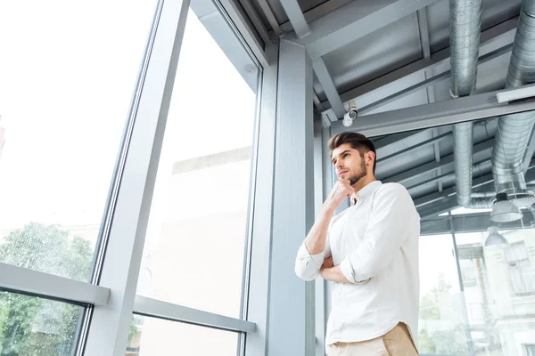 Nachdenklicher Mann, der nachdenkt und zum Fenster blickt — Stockfoto