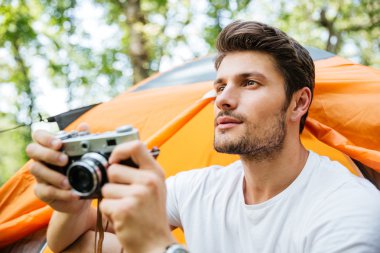 Adam ile orman turistik çadırın yakınında oturan eski fotoğraf makinesi