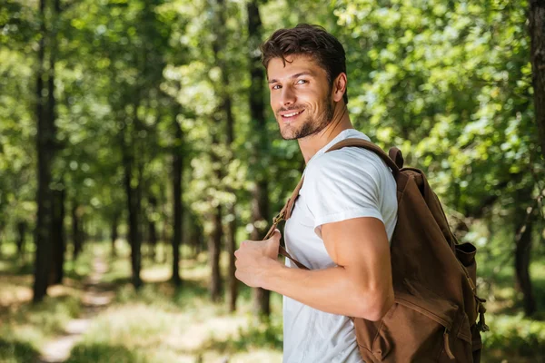 Człowiek z plecakiem spacerujący po lesie — Zdjęcie stockowe