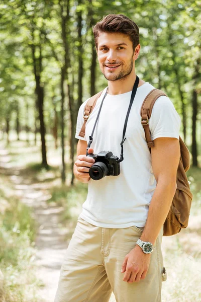 Χαρούμενος νεαρός φωτογράφος με σύγχρονη φωτογραφική στο δάσος — Φωτογραφία Αρχείου