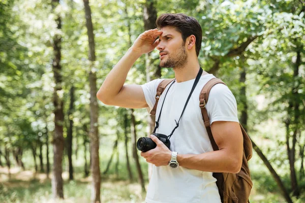 Hombre fotógrafo con cámara fotográfica moderna mirando lejos al aire libre —  Fotos de Stock