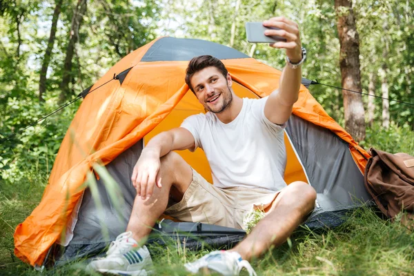 Man toeristische nemen selfie met mobiele telefoon in bos — Stockfoto