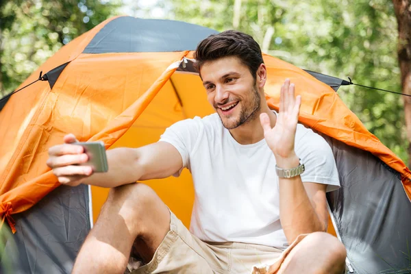 Uomo sorridente turista scattare selfie con smartphone alla tenda turistica — Foto Stock