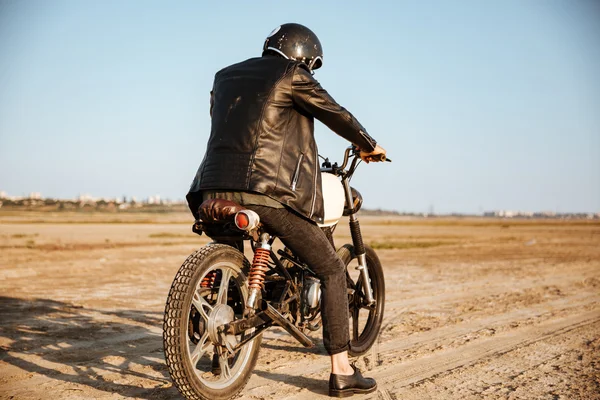 Обратный вид молодого жестокого человека за рулем мотоцикла — стоковое фото