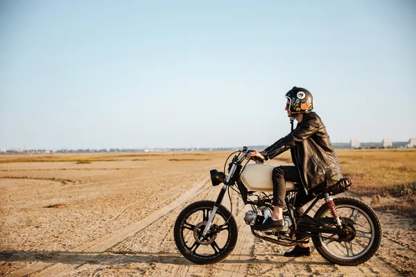 Young brutal man driving a motorcycle — Stock Photo, Image