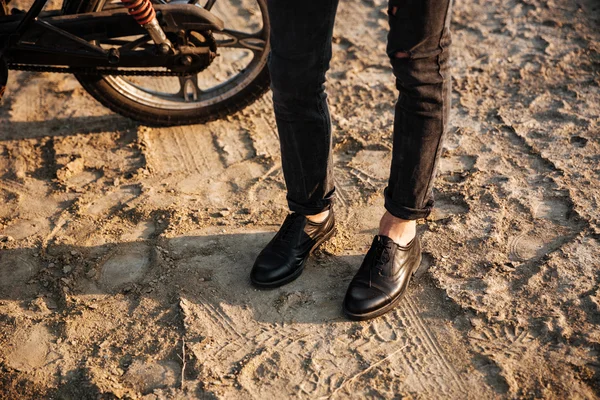 バイクの近くに立って男性足のトリミングされた画像 — ストック写真