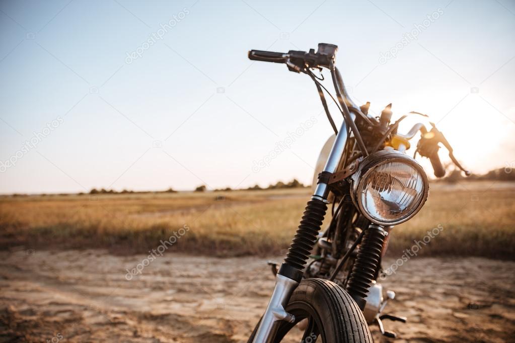 Close-up view on retro motorcycle headlights on the desert background