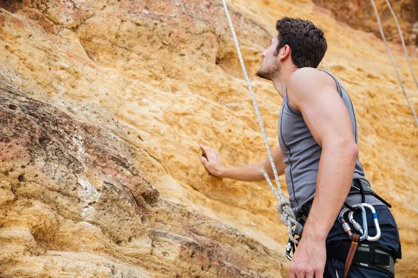 Fiatal jóképű sportoló felkészülnek arra, hogy mászni, egy cliff — Stock Fotó